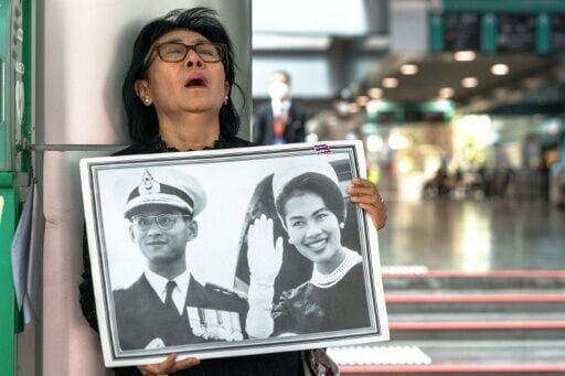 Thai mourner Kanjana Malaithong holds a portrait former queen Sirikit and king Bhumibol Adulyadej as she weeps at Chulalongkorn Hospital in Bangkok